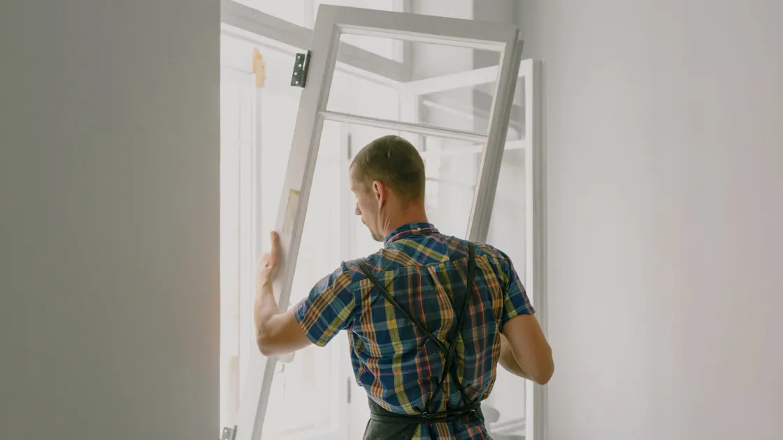 Installer fitting a hurricane impact window in a Tampa home